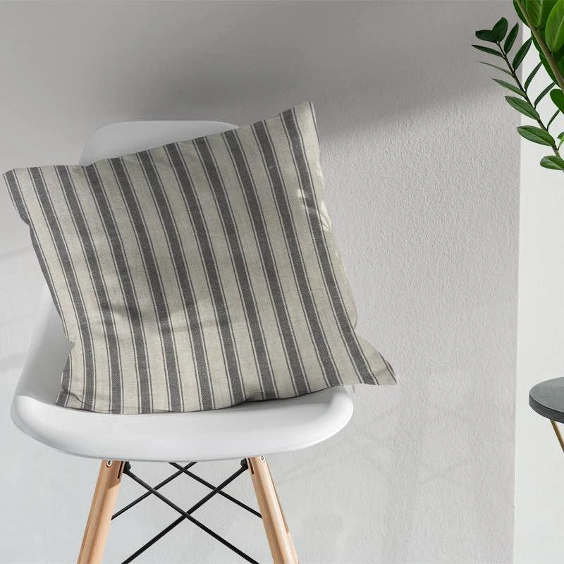 Striped fabric cushion in grey and cream tones on modern chair in minimalist room