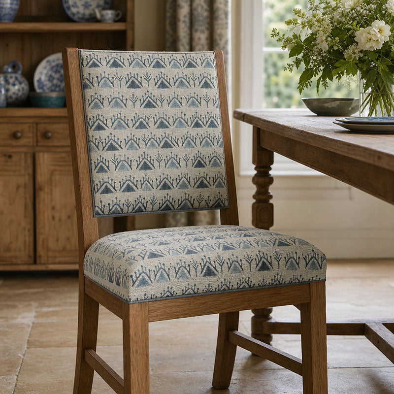 Azrou Aegean blue upholstery fabric on a dining chair, geometric Mediterranean print for statement seating
