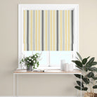 Boston Stripe Ochre Cotton Curtain Fabric styled as a Roman blind with bold yellow and grey stripes, perfect for contemporary spaces.