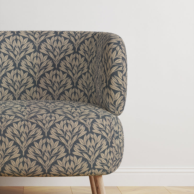 Chair upholstered in Driftwood Leaf Navy fabric, adding sophistication.