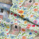 Close-up of Duck Egg Folk House curtain fabric gathered in soft folds with colourful floral print.