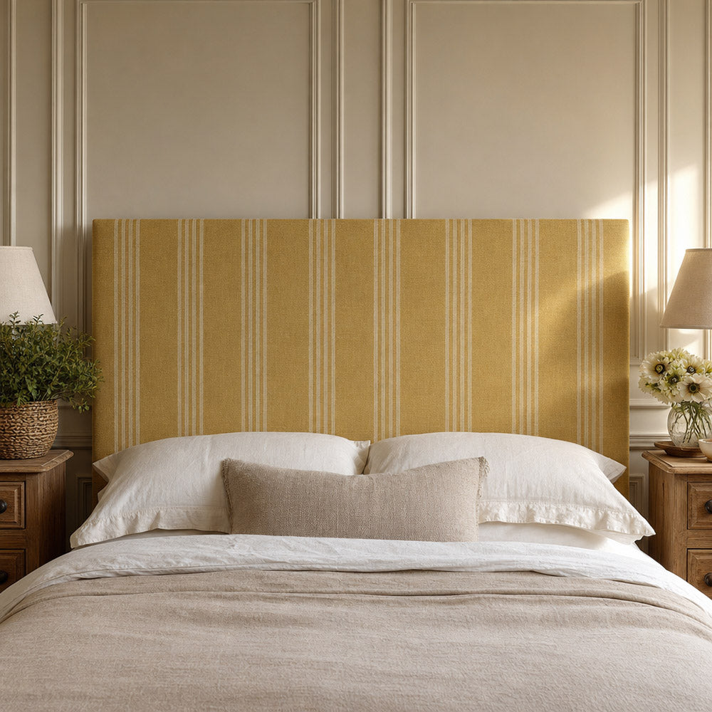 Hampton Ochre striped upholstery fabric shown on a headboard, warm patterned fabric for bedroom seating and soft furnishings