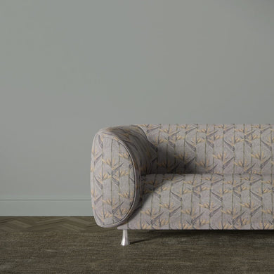 Holywell Leaf Dusk fabric shown on sofa with subtle botanical pattern