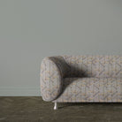 Holywell Leaf Dusk fabric shown on sofa with subtle botanical pattern