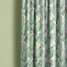 Linen curtain made from white jungle leaf fabric with green tropical foliage pattern.
