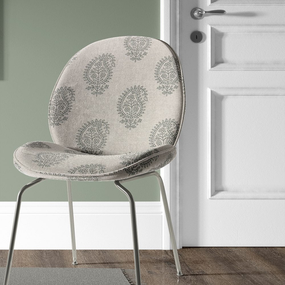 Kaveri Paisley Fennel upholstery fabric used on a chair, showcasing its elegant green-toned pattern