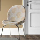 Kaveri Paisley Ochre upholstery fabric upholstered on a chair, creating a timeless vintage look