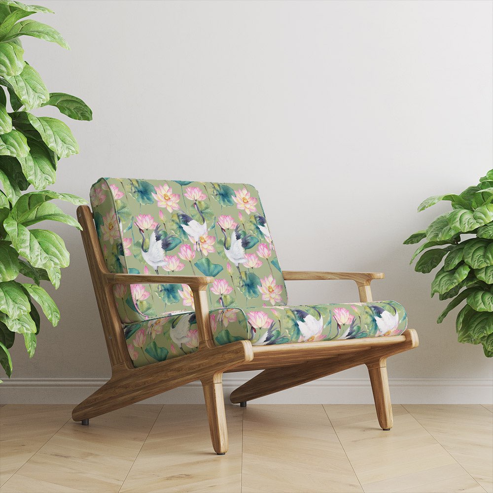 green crane velvet upholstery fabric on armchair showing japanese bird and lotus floral pattern in interior setting