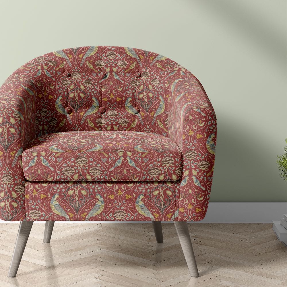 arts and crafts upholstery fabric with bird and floral pattern used on armchair in red william morris style design