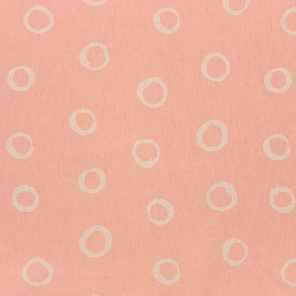 Blush spotted polka dot upholstery fabric with a soft pastel hue, perfect for adding warmth to furniture pieces.