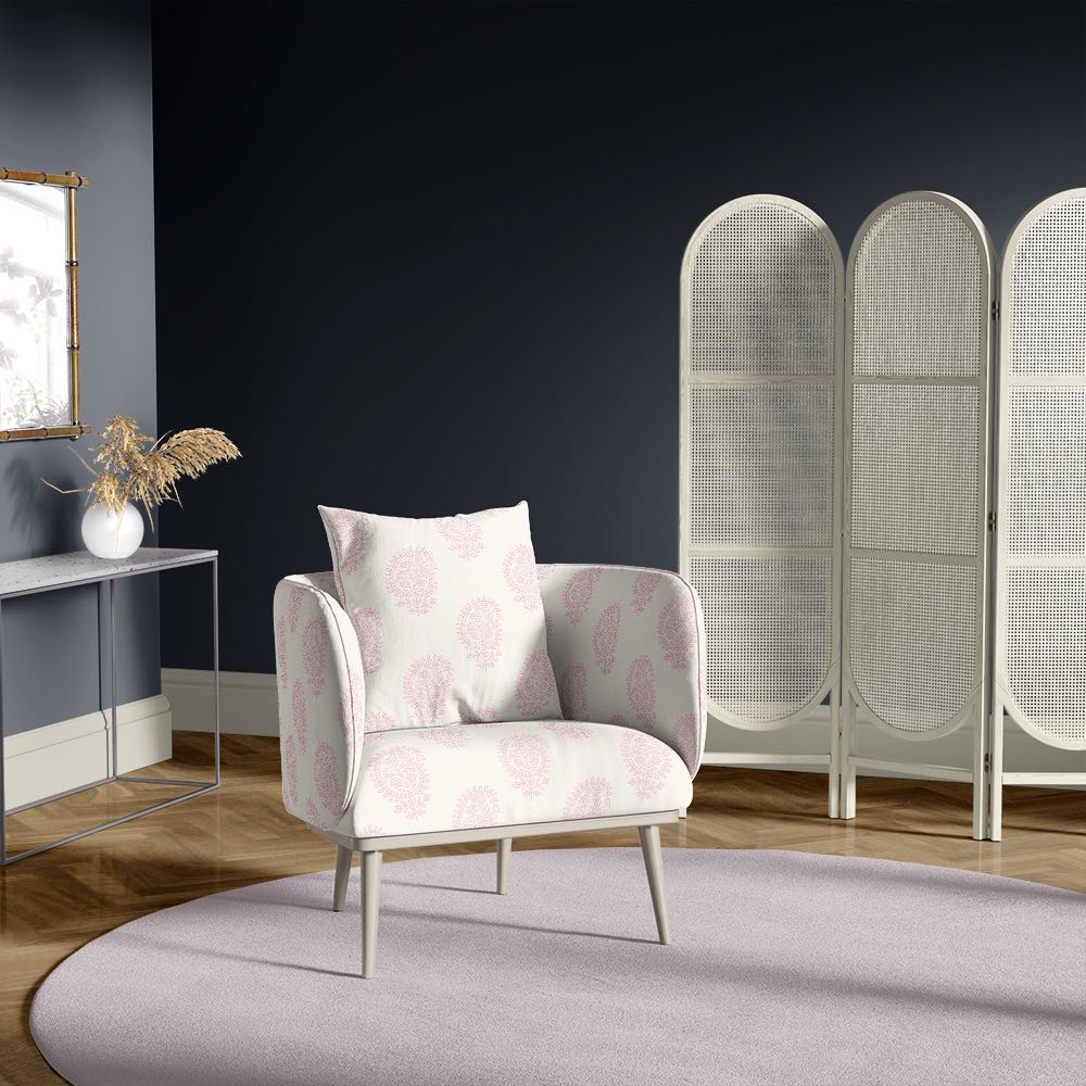 Armchair in paisley blush pink upholstery fabric, featured in a navy-walled room with soft lilac rug and vintage styling