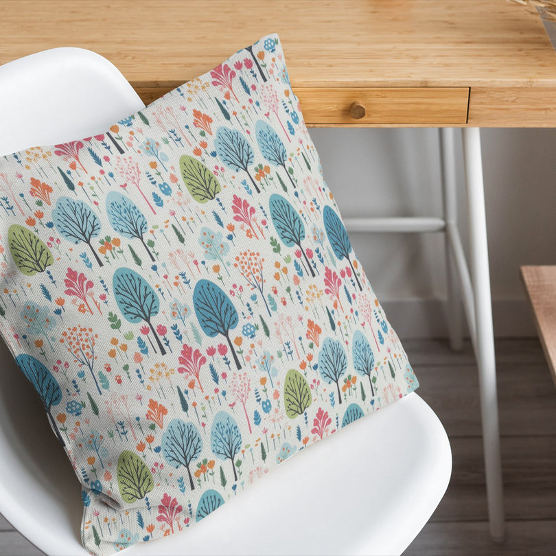 pastel trees cotton curtain fabric made into a decorative multicoloured cushion on a white chair