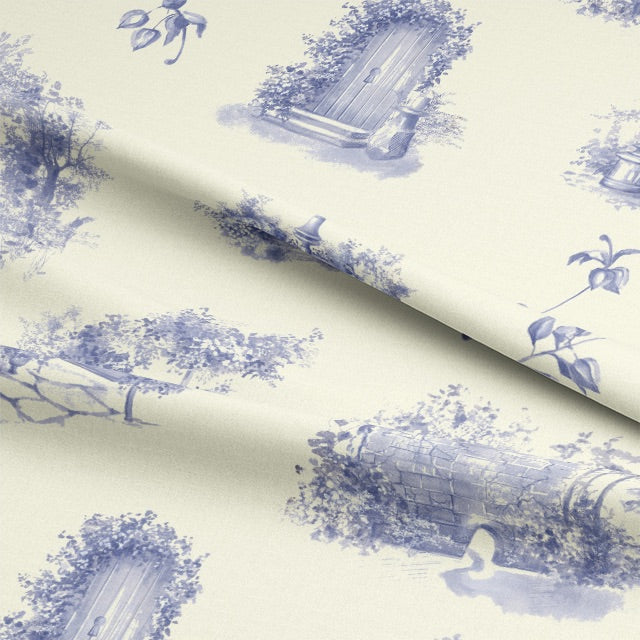 A folded piece of Aquitaine Toile Cotton Curtain Fabric in Blue Ivory, displaying its elegant blue and ivory color combination