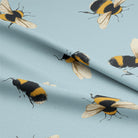 Soft and vibrant sky blue cotton fabric with bumble bee pattern
