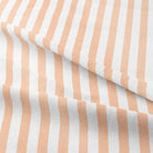 High-quality peach-colored cotton fabric printed with candy stripe pattern