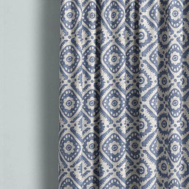 Ive Cotton Curtain Fabric - Blue hanging beautifully in a modern living room setting