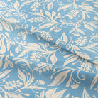 A close-up ruffled shot of the Oxford Wedgewood curtain fabric, showing the linen texture and intricate leaf pattern.
