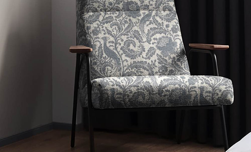 Denim patterned upholstery fabric on a modern armchair with dark backdrop
