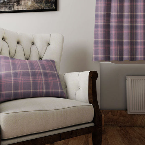 Traditional plaid curtain fabric in autumn tones of rust, navy, and cream displayed on a window