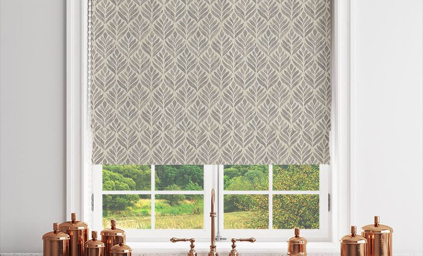 Dove grey Roman blind fabric with subtle leaf pattern styled in a modern kitchen window