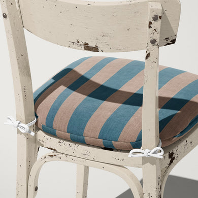 Altena Sky upholstery fabric styled on cushion – soft blue and neutral stripe design