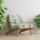 Amaranta Crib 5 floral velvet upholstery fabric shown on a chair with green tropical foliage