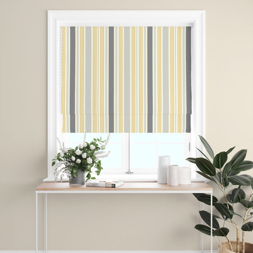 Boston Stripe Ochre Cotton Curtain Fabric styled as a Roman blind with bold yellow and grey stripes, perfect for contemporary spaces.