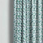 Cannock washable teal leaf fabric shown as full-length curtains in a calm contemporary room