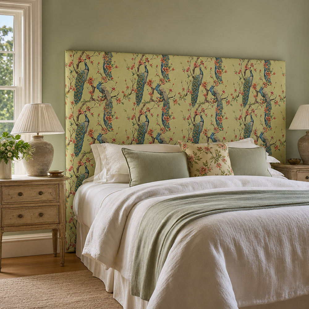 Chinoise Peacock Mint Green upholstery fabric shown on a headboard, decorative floral bird fabric for statement bedroom upholstery