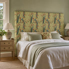 Chinoise Peacock Mint Green upholstery fabric shown on a headboard, decorative floral bird fabric for statement bedroom upholstery