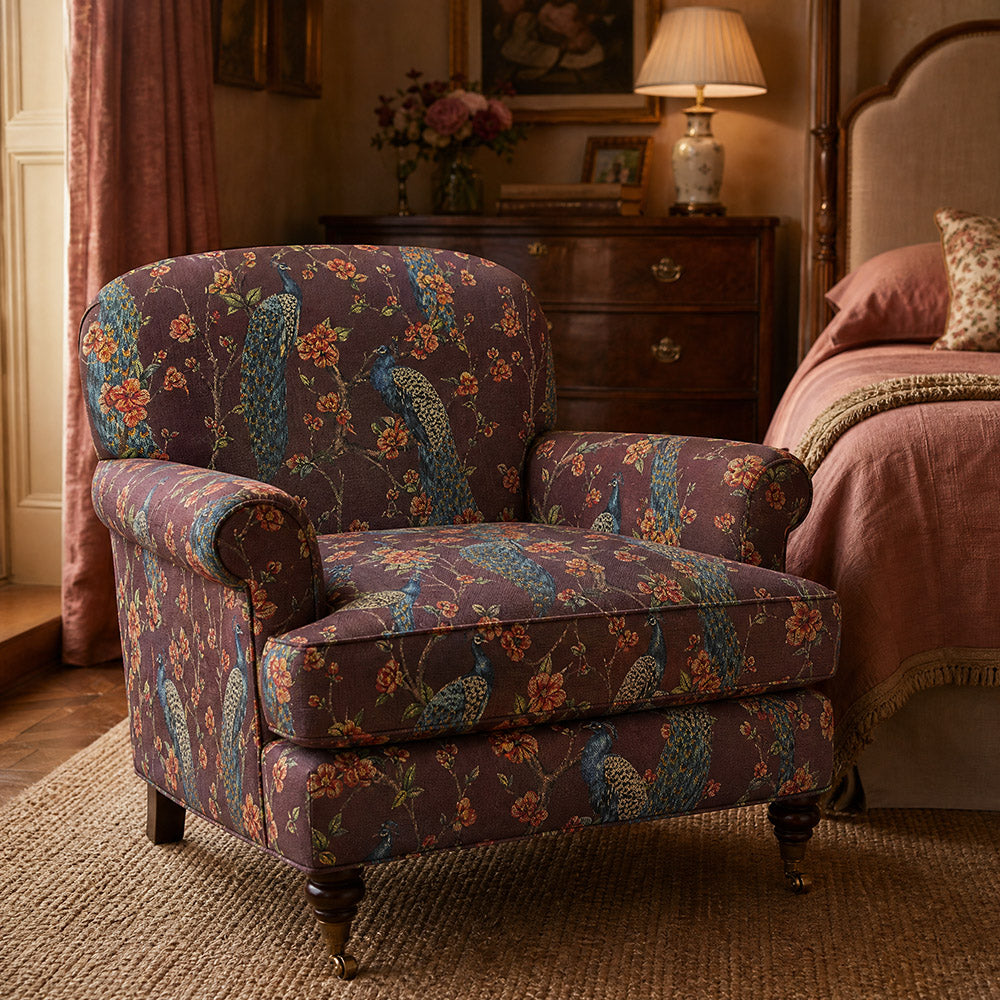 Chinoise Peacock Wine upholstery fabric shown on an armchair, decorative bird and floral fabric for colourful upholstery projects