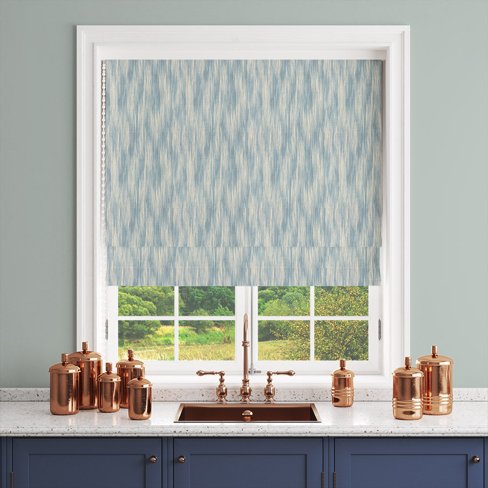 Roman blind in Dallas Blue striped curtain fabric, styled in a window with soft mid-blue brushstroke stripes.