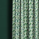 Darwin leaf fabric shown as full-length green curtains in a light botanical interior
