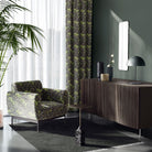 Deco Leaf Green linen curtain fabric featured on matching curtains and armchair in a contemporary interior space