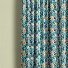 Delamere washable leaf fabric made into patterned curtains with teal, navy and green foliage