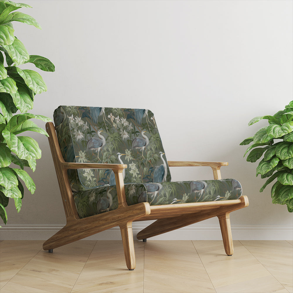 Armchair upholstered in Ellesmere Heron velvet fabric with forest green heron and tropical foliage design