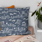 Blue horse print curtain fabric shown on a decorative cushion in a traditional country interior