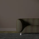 Feathered Velvet ebony gold upholstery fabric shown on a sofa with feather pattern