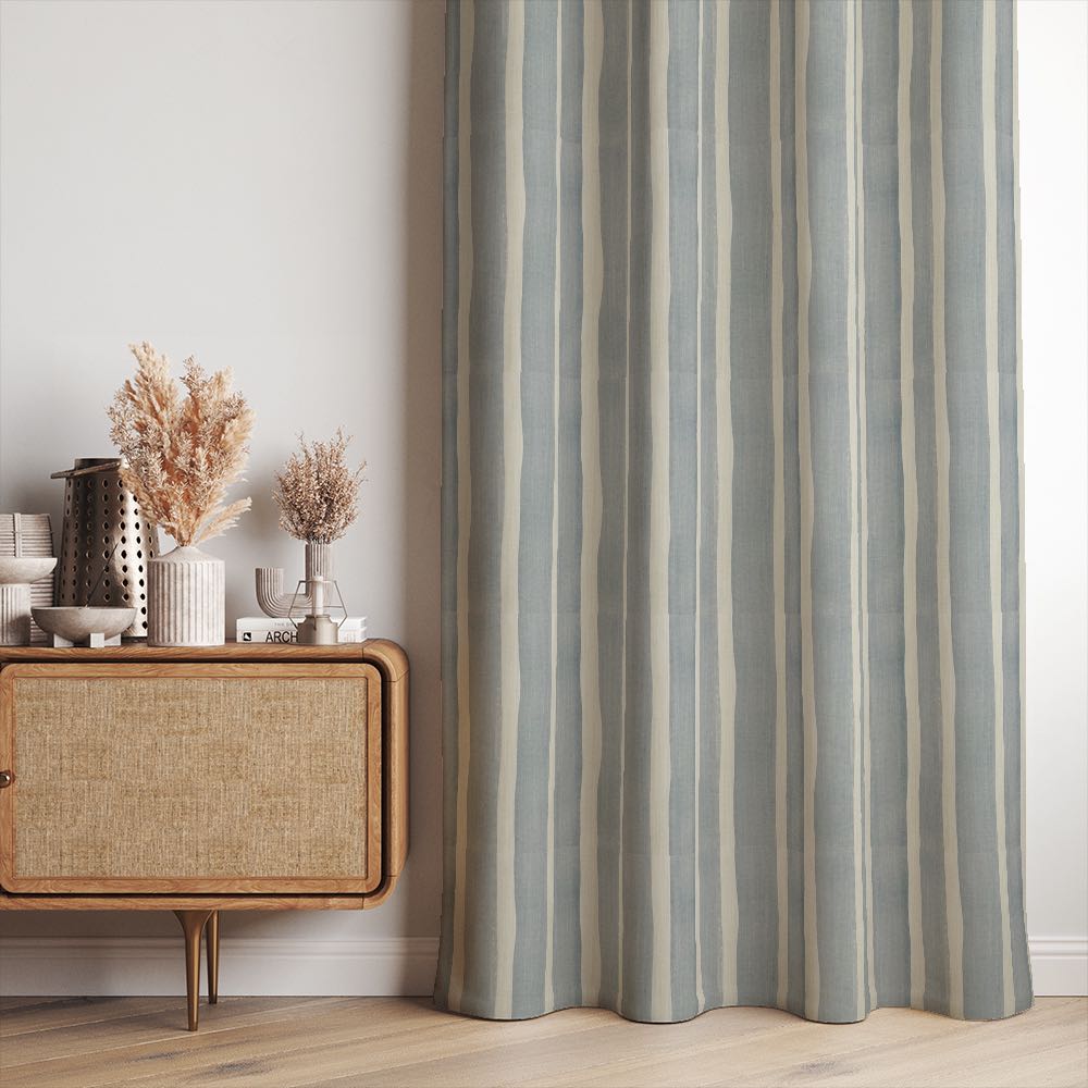 Fresno Stripe Ice linen curtain fabric shown as full-length curtains in a soft, coastal interior with pale blue vertical stripes