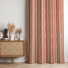 Fresno Stripe Peach linen curtain fabric styled as curtains with warm coral and terracotta stripes in a sunlit modern room