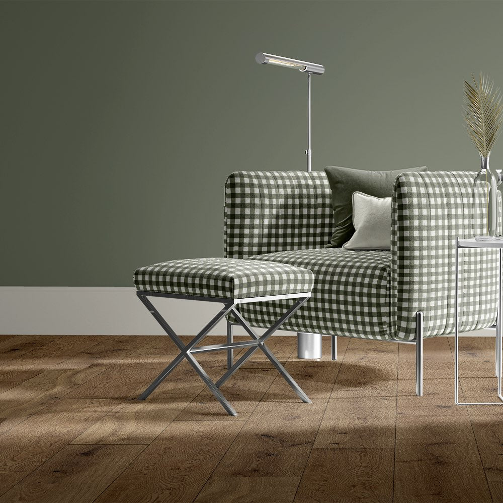 Gingham check upholstery fabric in green on armchair and footstool, styled in a modern green-toned interior.