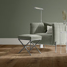 Gingham check upholstery fabric in green on armchair and footstool, styled in a modern green-toned interior.