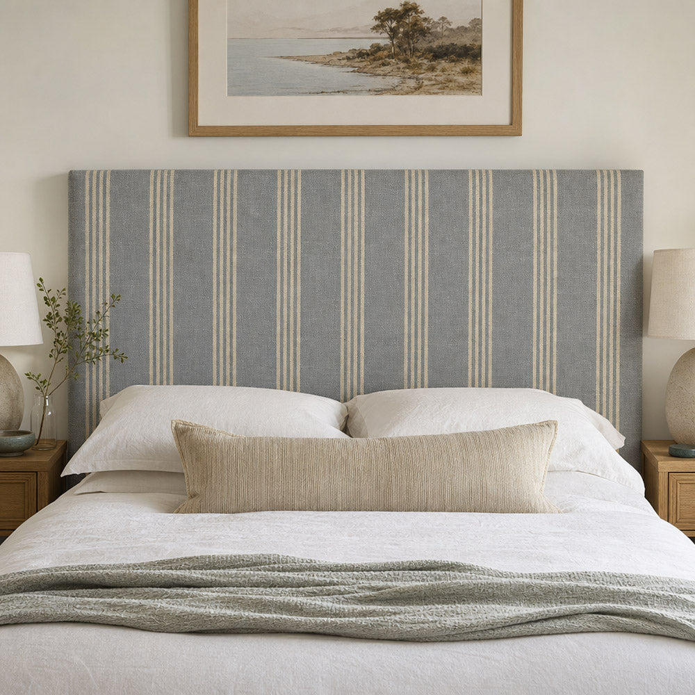 Hampton Denim striped upholstery fabric displayed on a headboard, blue striped fabric for bedroom upholstery and soft furnishings