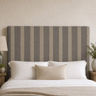 Hampton Slate striped upholstery fabric shown on a headboard, tailored striped fabric for bedroom upholstery and cushions