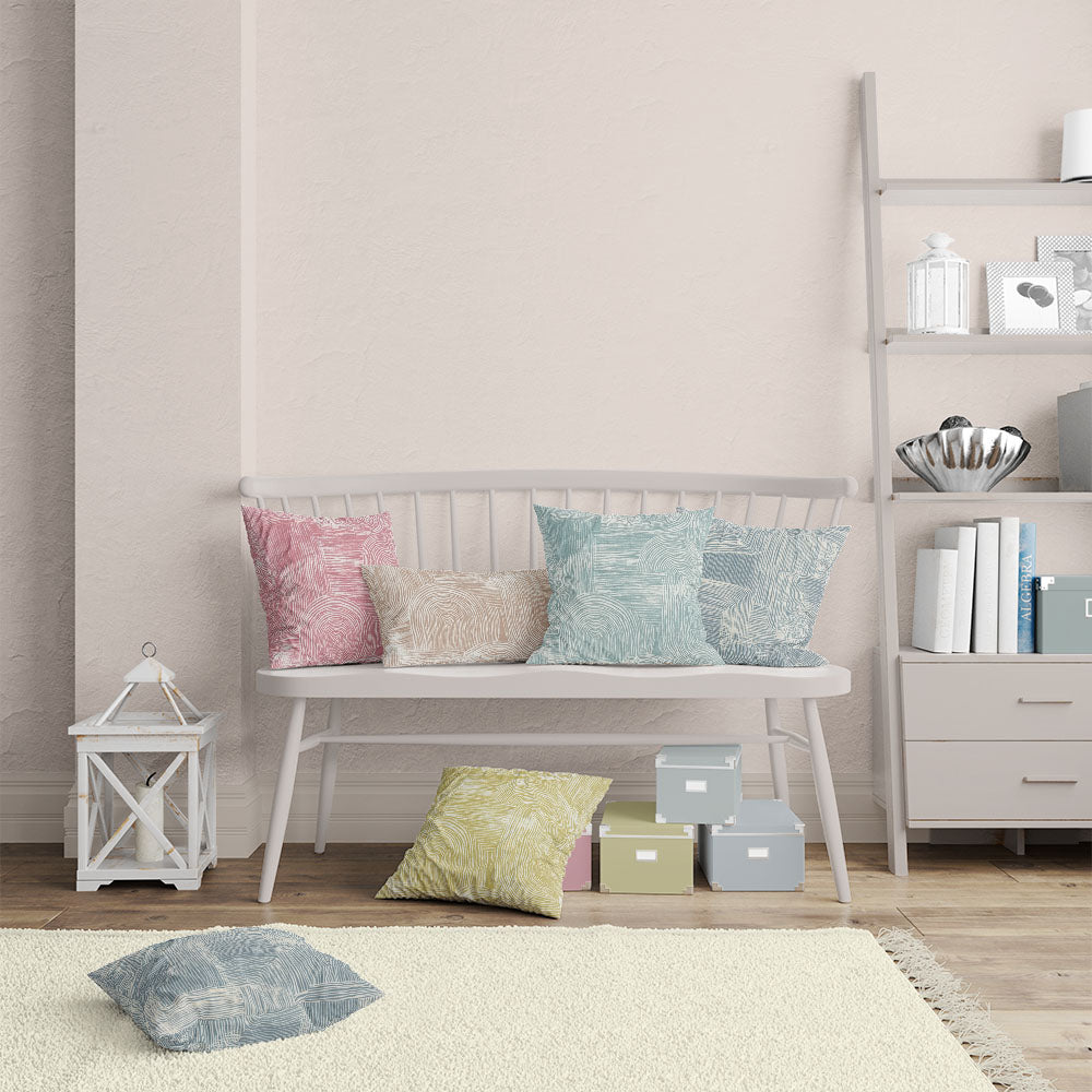     multicolour cushion display featuring hand drawn cotton curtain fabric in blush green blue and ochre tones