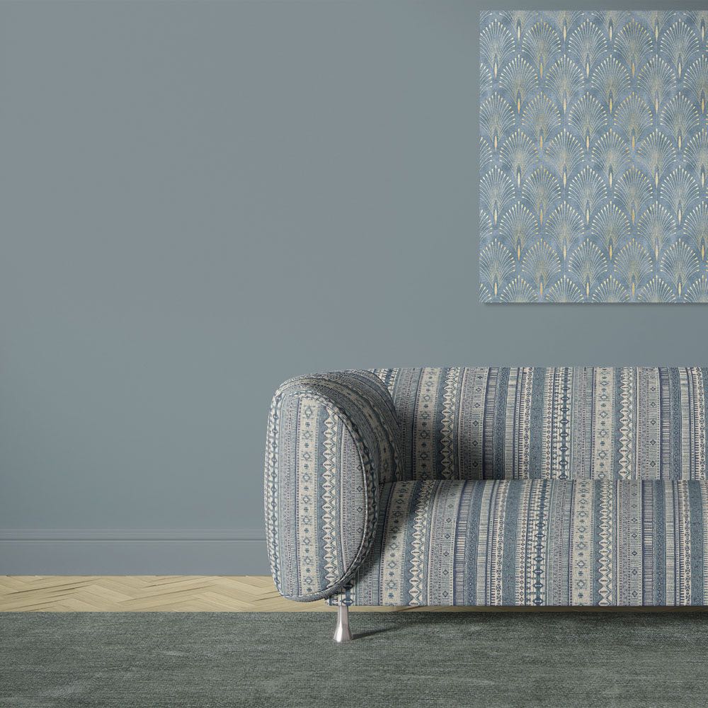 Khenifra Sapphire velvet upholstery fabric shown on a sofa with vertical kilim stripe design