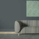 Khenifra Teal velvet upholstery fabric shown on a sofa with vertical kilim inspired stripe pattern