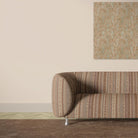 Khenifra Terracotta velvet upholstery fabric shown on a sofa with warm vertical stripe pattern