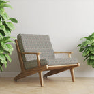 black geometric velvet upholstery fabric on armchair showing structured repeat pattern in modern interior setting