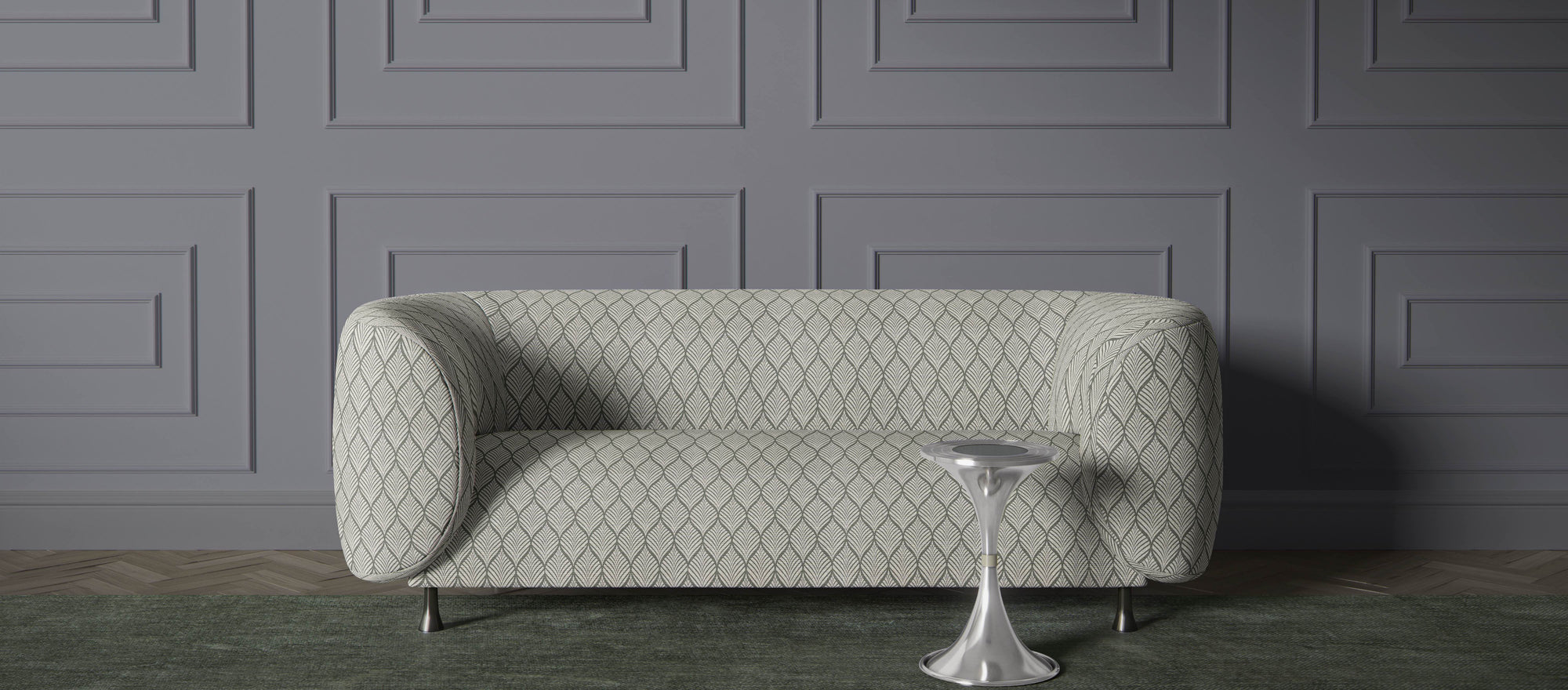 Modern sofa upholstered in green leaf patterned upholstery fabric, styled against a grey panelled wall – premium upholstery fabric for stylish interiors.